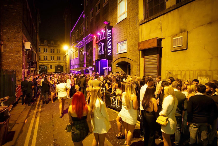 Clubbers outside Mansion Club on Temple Street at night