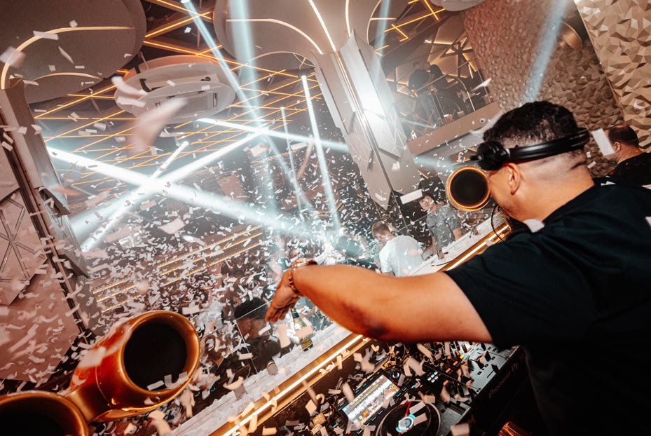 DJ at the decks with confetti coming down in the club