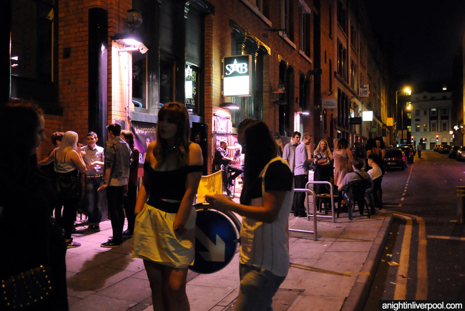 Street view of Stanley Street, Liverpool, with crowds of people outside Superstar Boudoir.