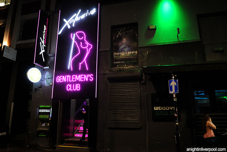 Xclusive gentlemen's club at night showing branding in neon lights 